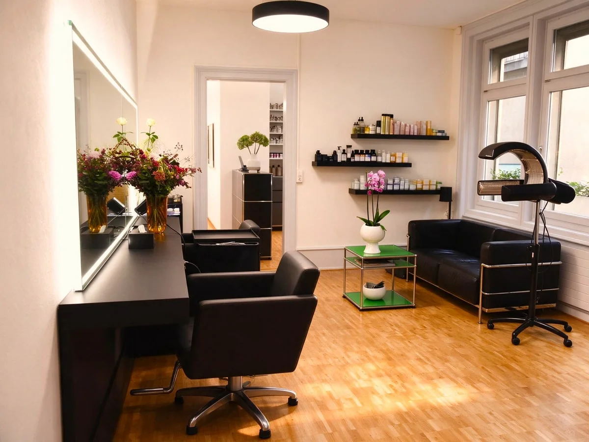 Frisierplätze im Salon mit Spiegeln und feinen Blütenarrangements